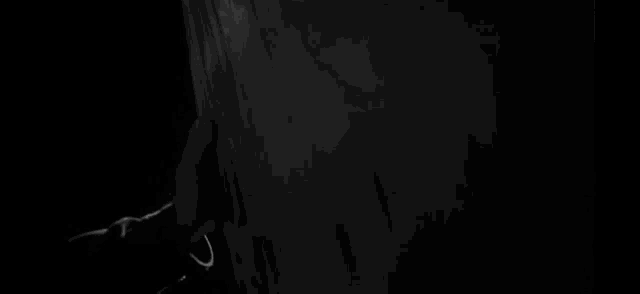 a black and white photo of a person holding a sword .