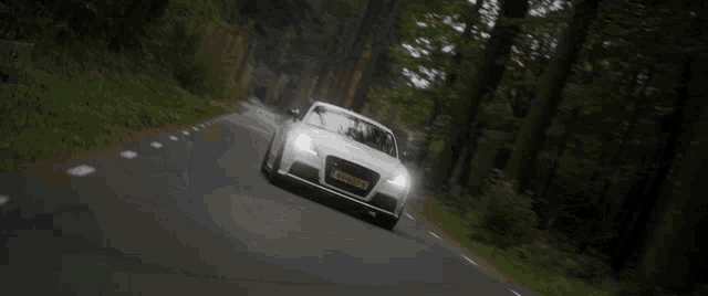 a white car is driving down a road with a license plate that says rv-gsdp