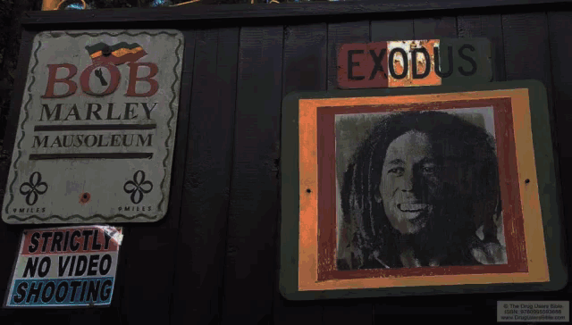 a sign for bob marley mausoleum has a picture of bob on it
