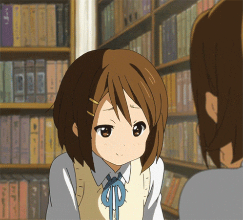a girl with brown hair is standing in front of a bookcase