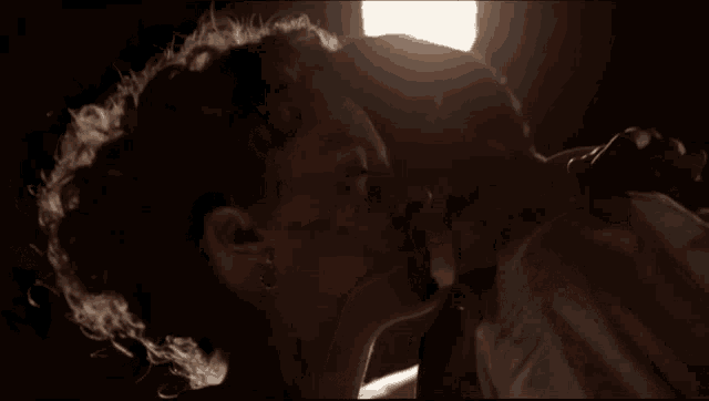 a woman kissing a man in a dark room
