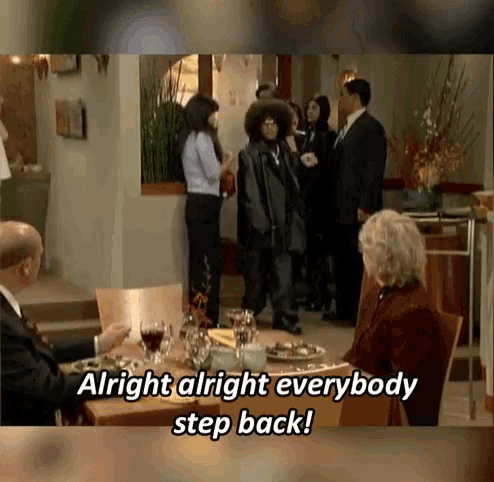 a group of people sitting at a table with the words alright alright everybody step back below them