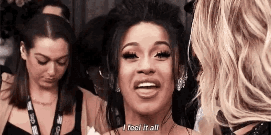 a woman is smiling and saying `` i feel it all '' while talking to another woman .