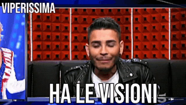 a man in a leather jacket is sitting in front of a wall that says viperissima ha le visioni