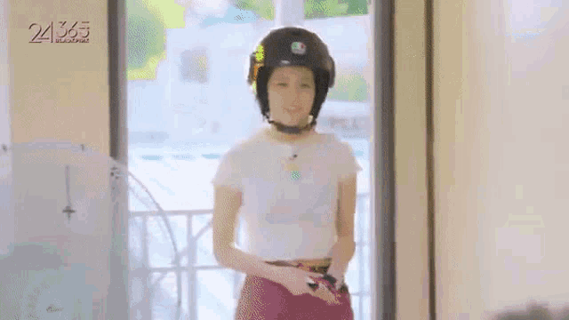 a woman wearing a helmet is standing in a doorway .