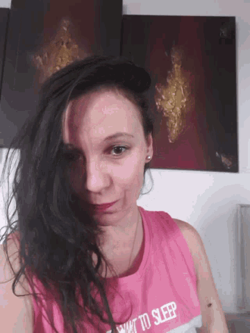 a woman wearing a pink shirt that says how to sleep on it