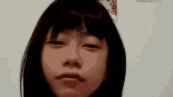 a young girl with short hair is making a funny face .