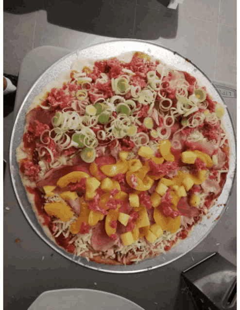 a pizza with a lot of toppings on it including pineapple