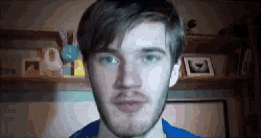 a close up of a man 's face with a beard and blue shirt .
