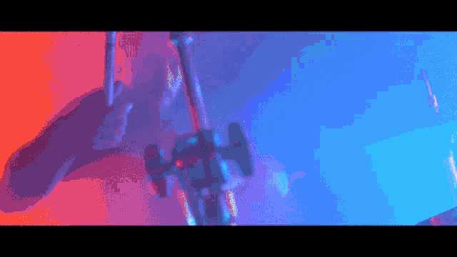 a man is playing drums in a dark room with blue and red lights