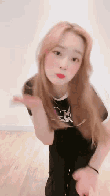 a woman with blonde hair and red lipstick is kneeling down on the floor .