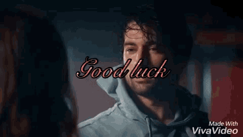 a man and a woman are looking at each other and the words good luck are on the screen .
