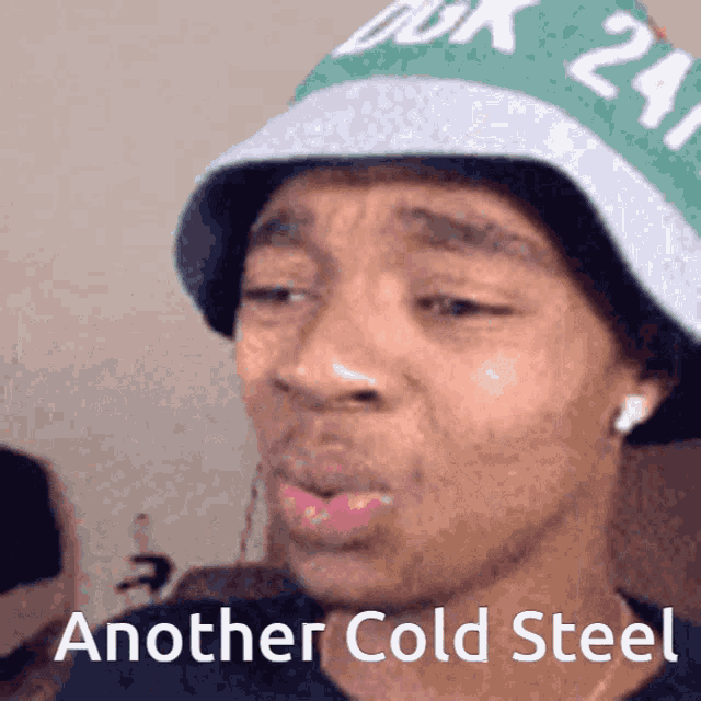a man wearing a green and white hat with the words another cold steel