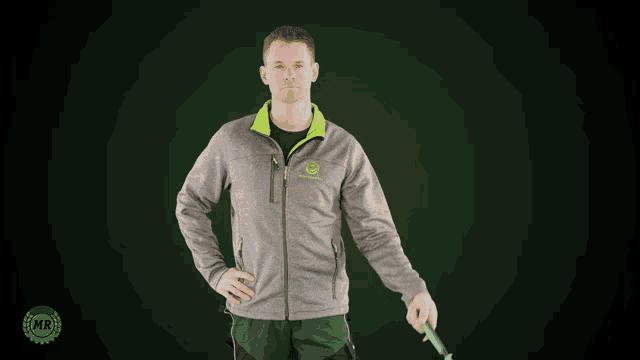 a man in a john deere jacket holds a hammer above his head