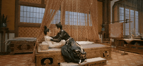 a man and a woman are kissing on a bed