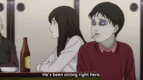 a man with a cigarette in his mouth is sitting next to a woman who is sitting at a table with a bottle of beer
