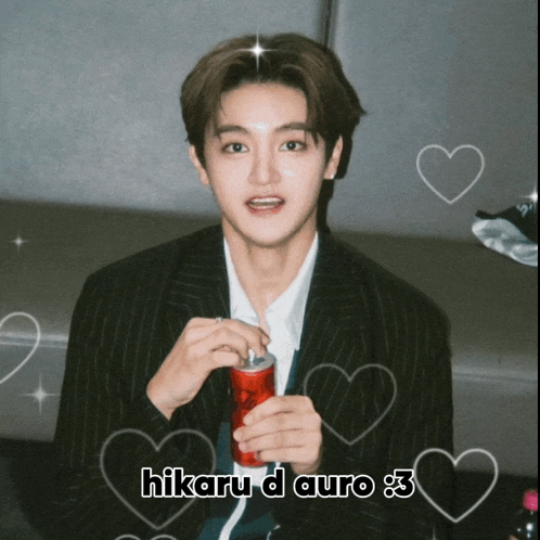 a young man in a suit is holding a can of soda and the caption says hikaru d auro