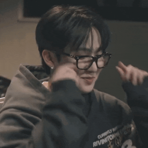 a close up of a person wearing glasses and a sweatshirt that says river camp