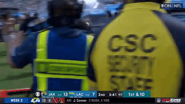 a man wearing a yellow vest with the word csc on it