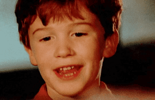 a close up of a young boy 's face with a few missing teeth