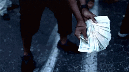 a man is holding a fan of money in his hand .