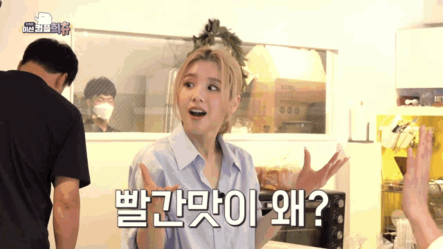 a woman in a blue shirt is asking a question in a kitchen