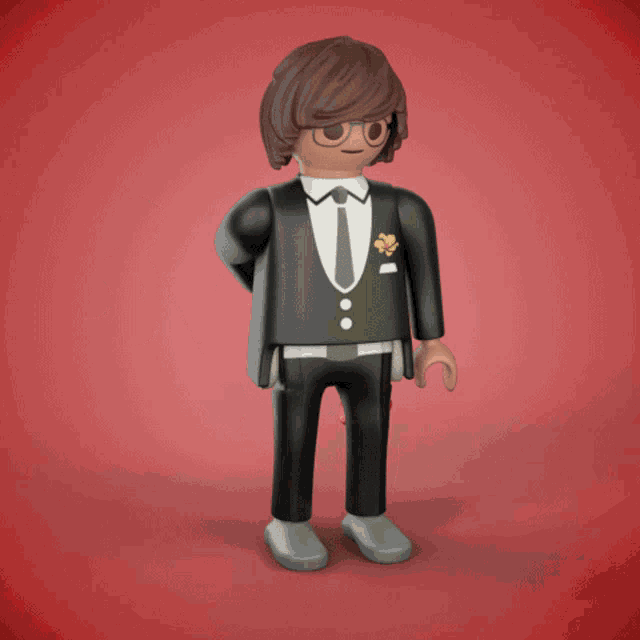a playmobil figure in a tuxedo holding a red rose