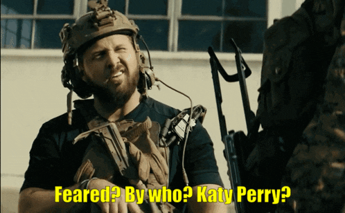 a man in a helmet says feared by who katy perry while holding a gun
