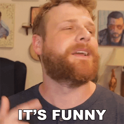 a man with a beard says it 's funny in front of some pictures