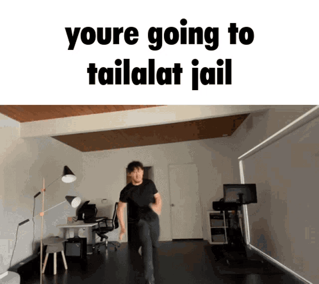 a man in a black shirt is dancing in a room with the words you 're going to tailalat jail above him