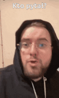 a man wearing glasses and a hooded jacket is making a funny face .