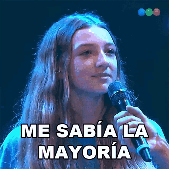 a woman singing into a microphone with the words me sabia la mayoria written below her