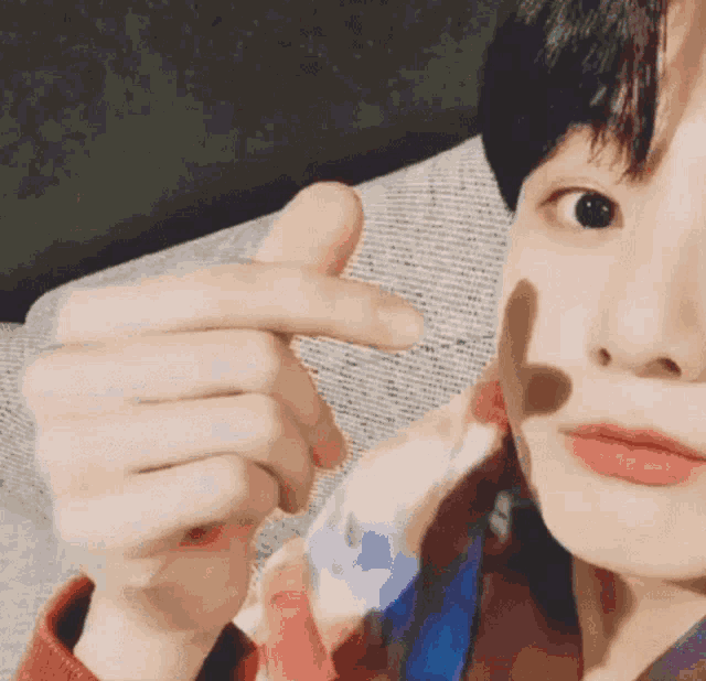 a close up of a person making a heart shape with their hands