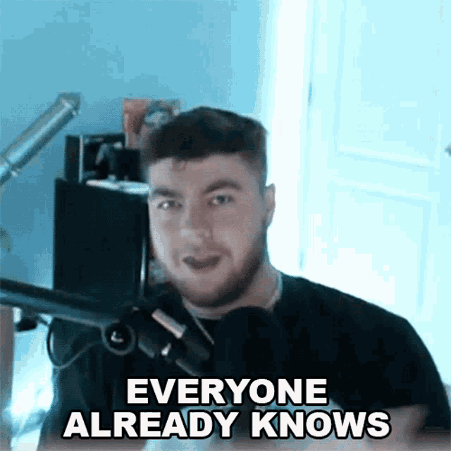 a man standing in front of a microphone with the words everyone already knows above him
