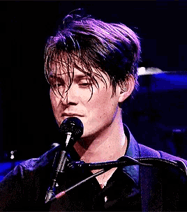 a man singing into a microphone while wearing ear buds