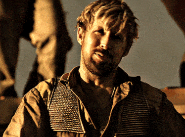 a man with a beard is wearing a brown shirt with suspenders