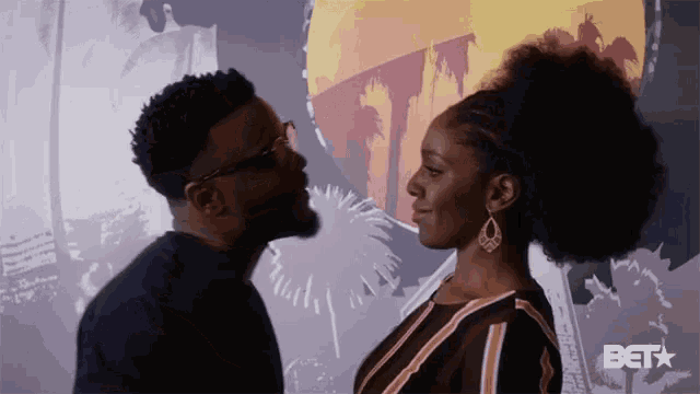 a man and woman are looking at each other with a bet logo behind them