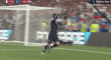 a soccer player jumps in the air during a game with the score 2 to 1