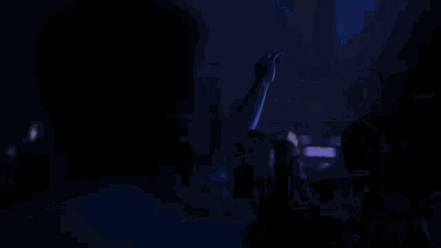 a person 's hand is reaching up in the air in front of a microphone