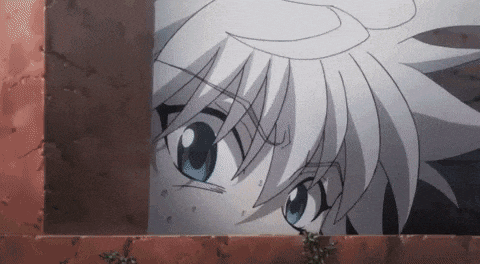 a close up of a person 's face peeking out from behind a brick wall .