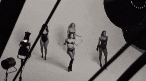 three women in lingerie are dancing in a black and white photo