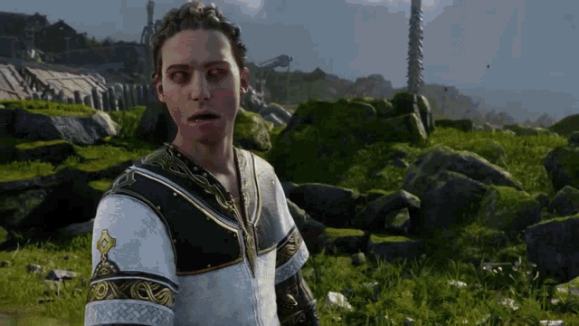 a man in a white and black outfit stands in a field of grass and rocks
