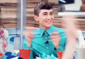 a man in a green shirt is sitting at a table