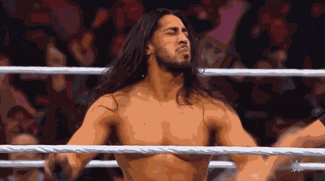 a shirtless wrestler in a wrestling ring with a w logo on the bottom right