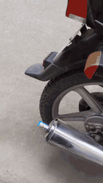 a motorcycle with a toothpaste tube attached to the exhaust