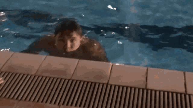 a man is swimming in a swimming pool with his mouth open and his eyes closed .