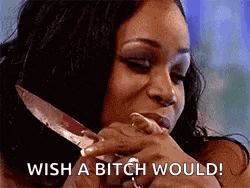 a woman is holding a knife in her mouth and says `` wish a bitch would '' .