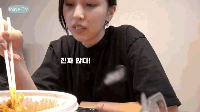 a woman is sitting at a table with a bowl of food and a mina tv logo