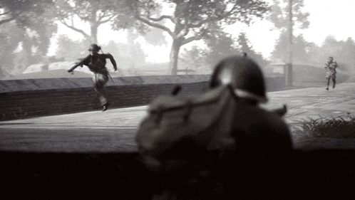 a black and white photo of two soldiers running
