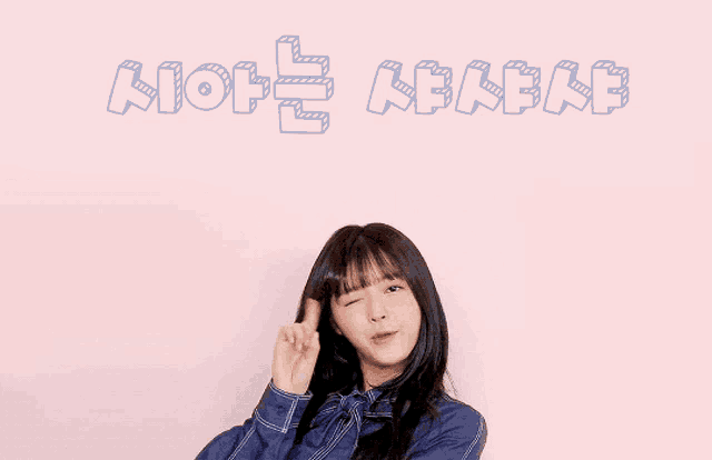a girl pointing up in front of a pink wall that says ' aion ' on it
